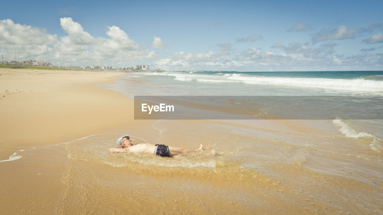 High angle view of man lying on beach