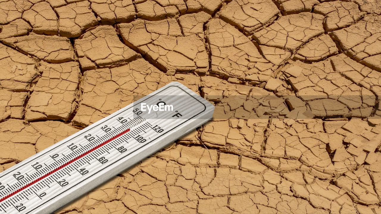 Close-up of thermometer on barren land