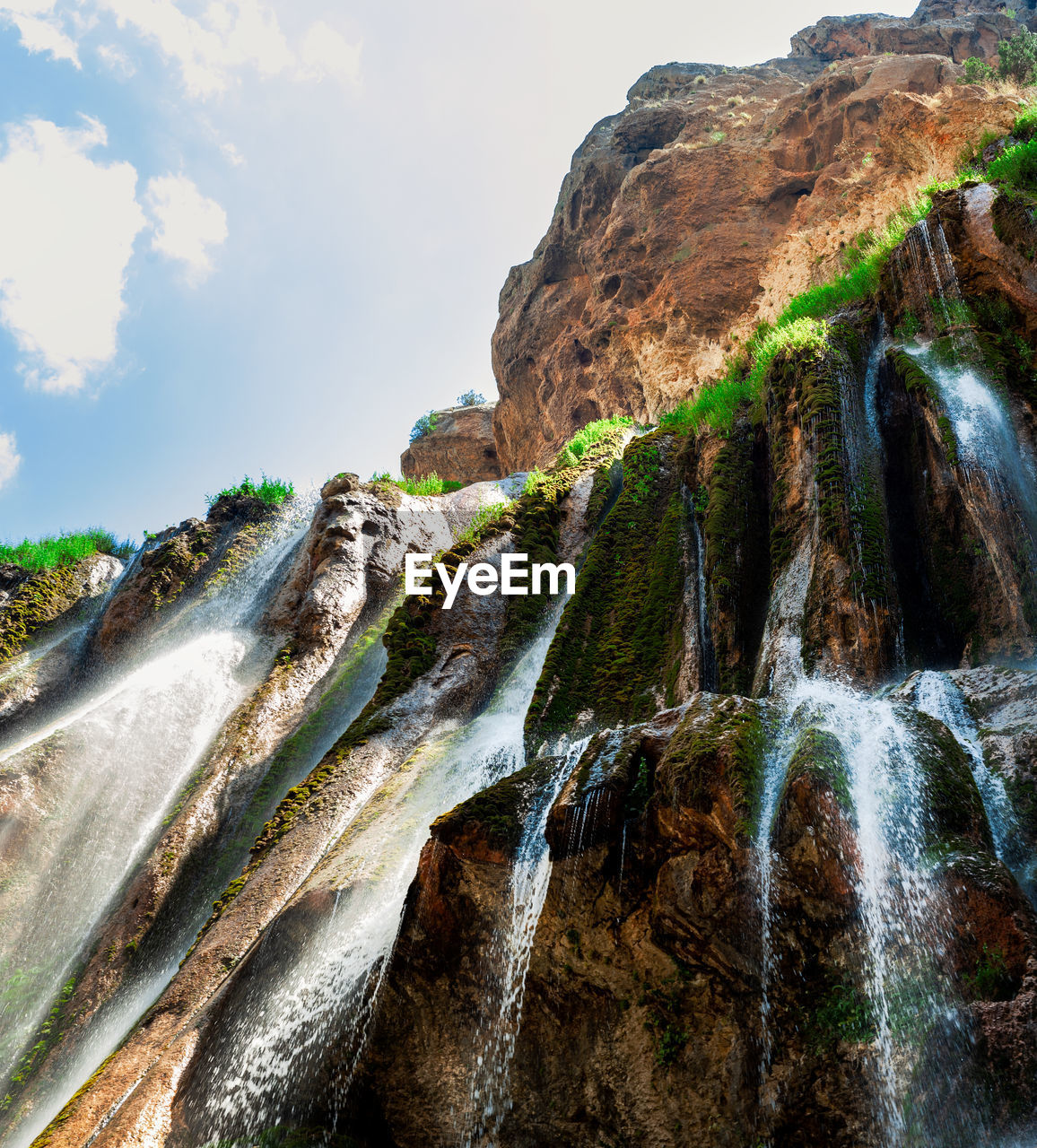 SCENIC VIEW OF WATERFALL AGAINST ROCK FORMATION