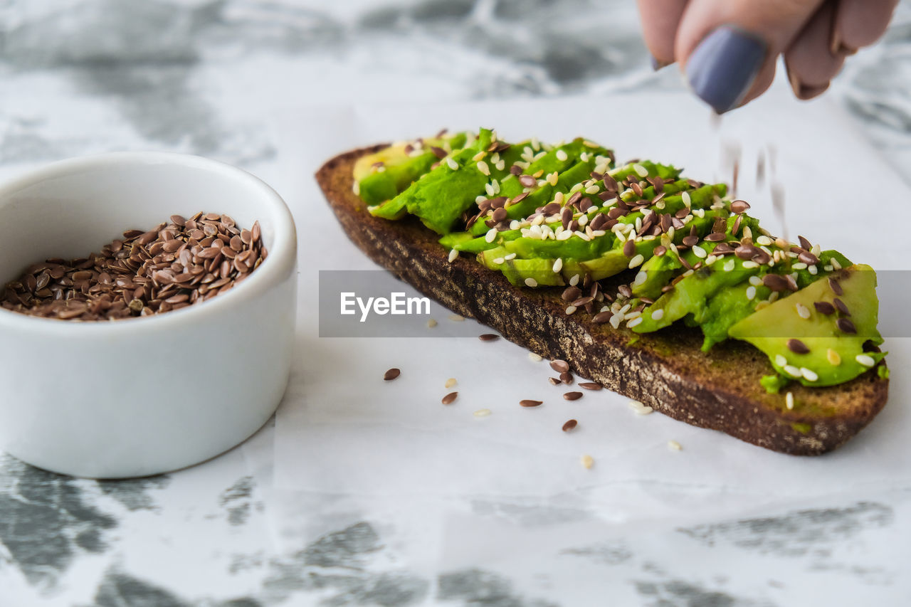 Healthy avocado toast on concrete background. wholegrain bread, sesame flax seeds. vegan keto diet.