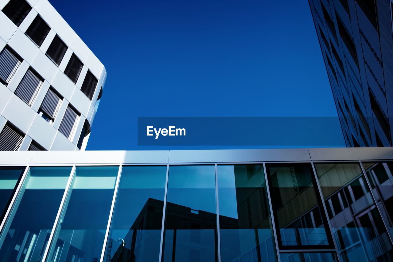 Low angle view of modern building against clear blue sky