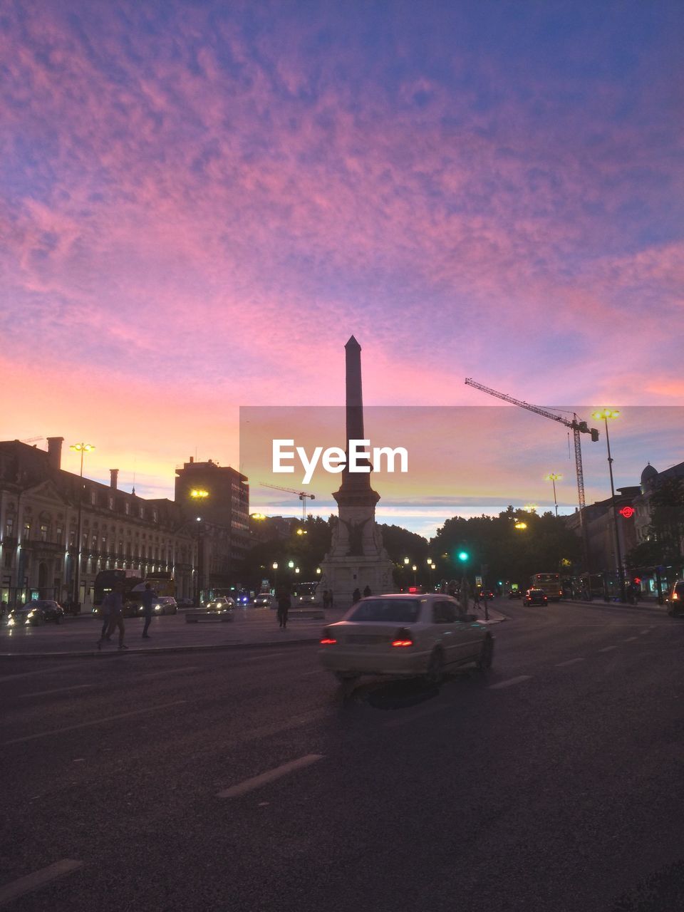 CARS MOVING ON ROAD AT SUNSET