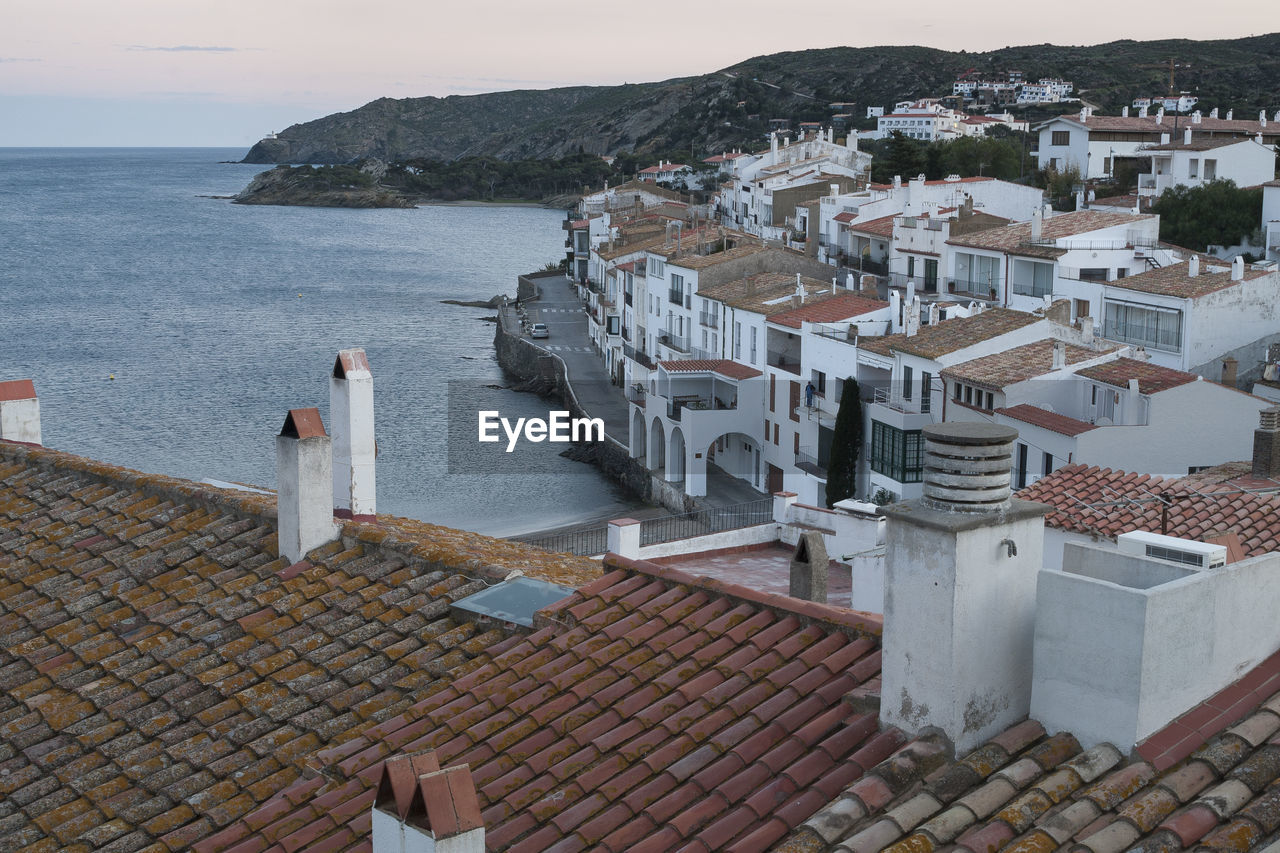 High angle view of townscape by sea against sky riva pitxot cadaquès alt empordà. girona. spain.