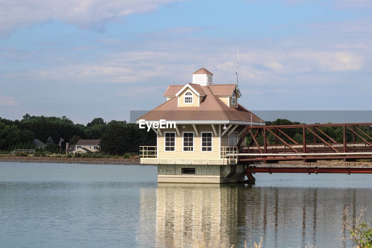 HOUSE BY RIVER AGAINST SKY AND BUILDING