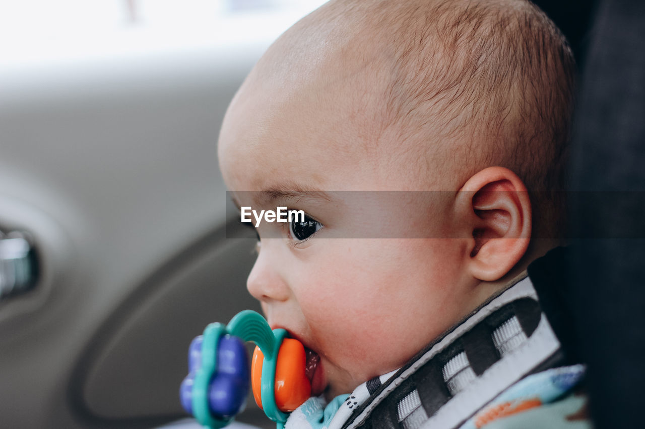 Sweet little baby boy in the car in baby safety seat