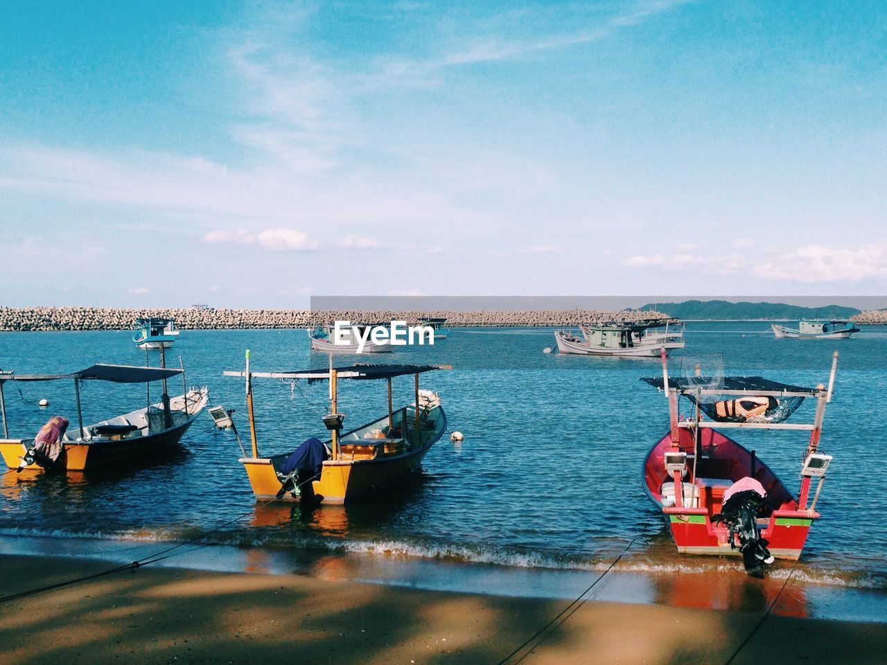 Boats moored on sea against sky