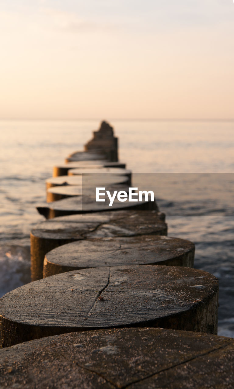 WOODEN PIER ON SEA AGAINST SKY AT SUNSET