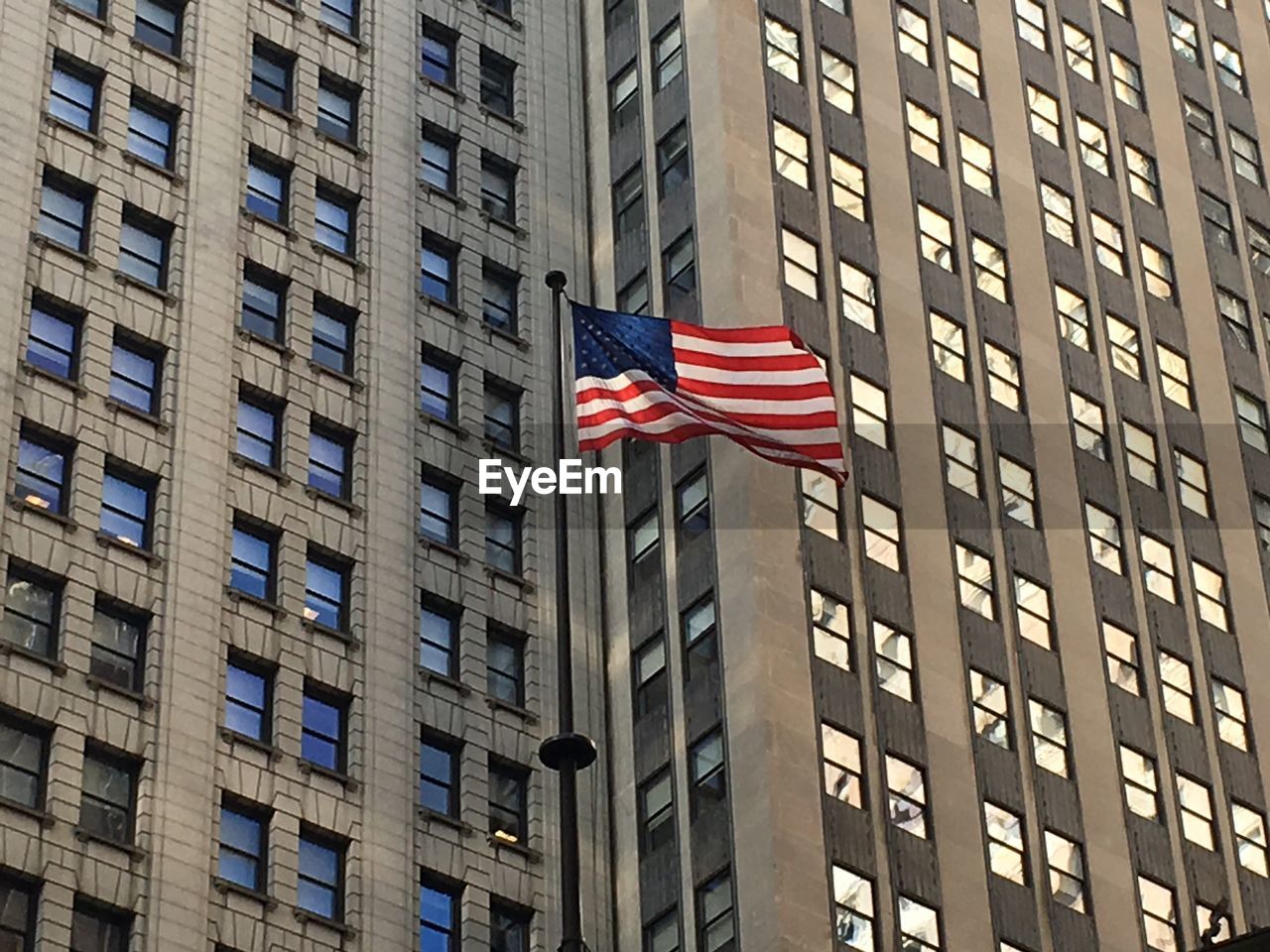 Low angle view of american flag 8against buildings