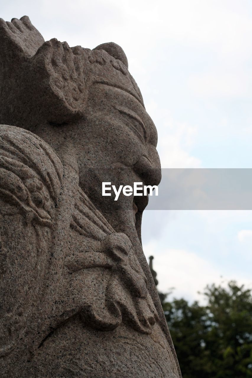 CLOSE-UP OF STATUE AGAINST SKY