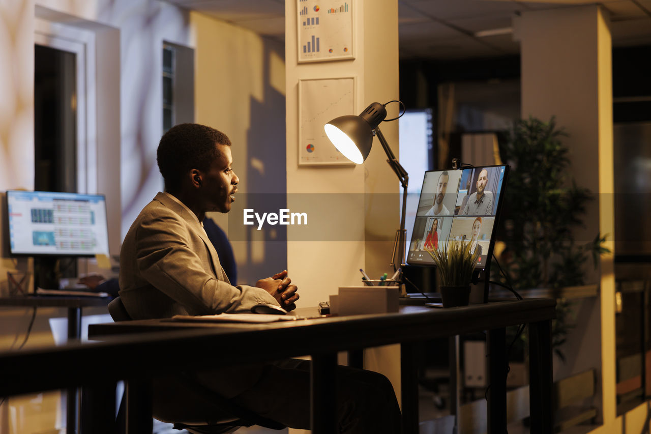 rear view of man using digital tablet while sitting at office