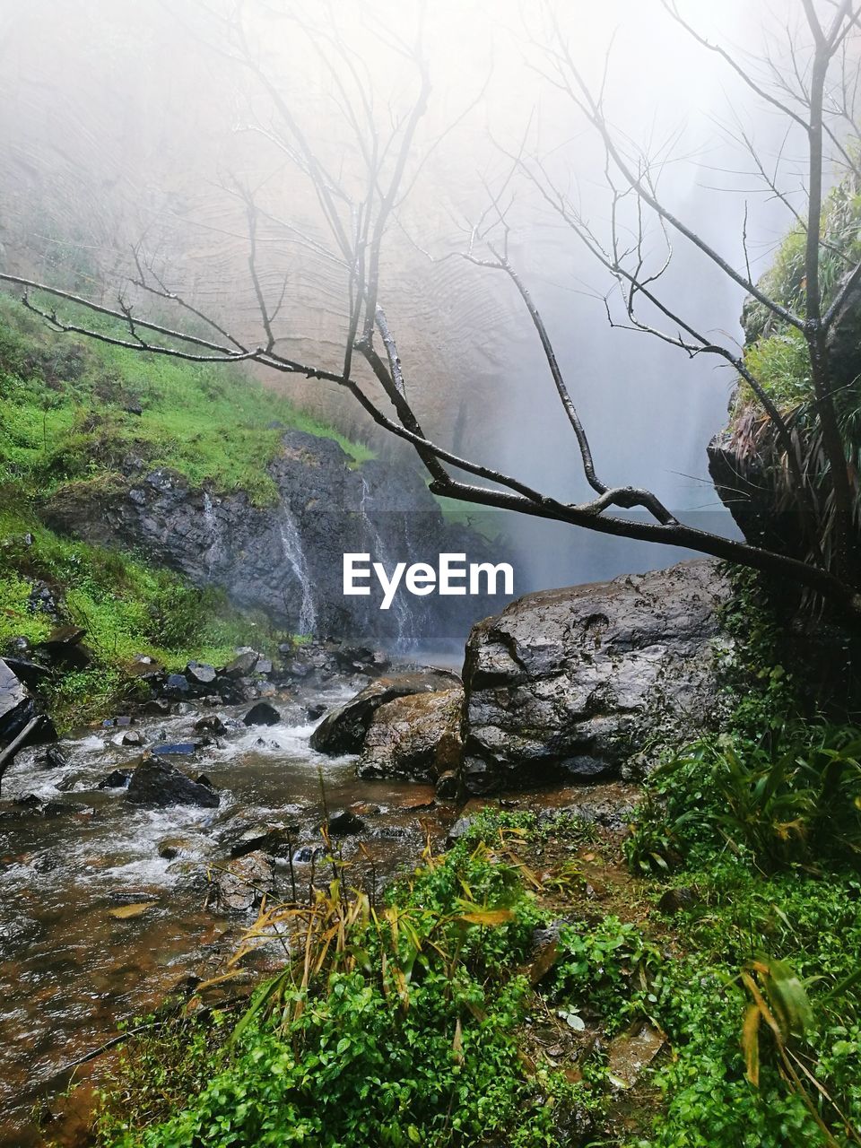 SCENIC VIEW OF WATER FLOWING THROUGH ROCKS