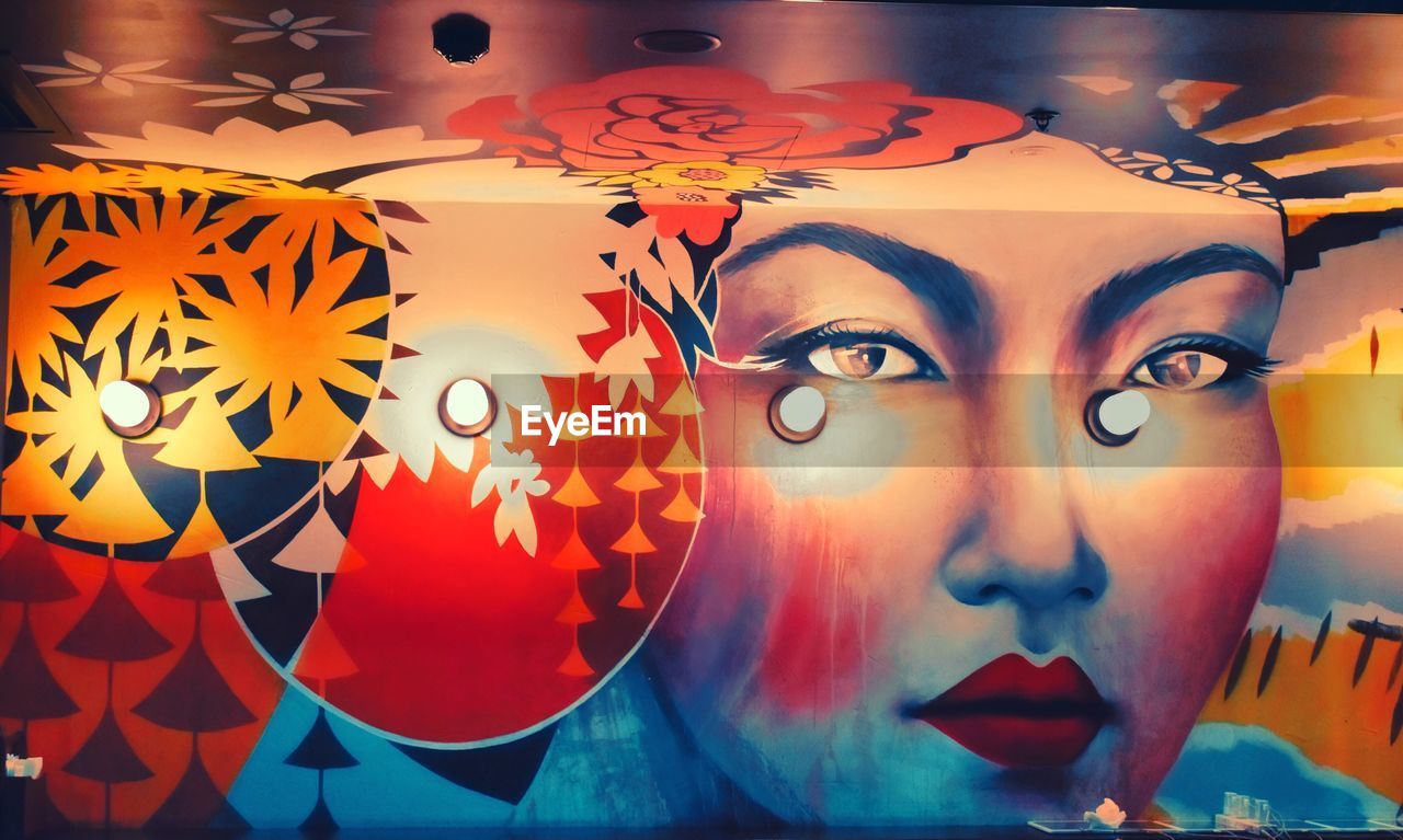 CLOSE-UP PORTRAIT OF YOUNG WOMAN AGAINST GRAFFITI WALL