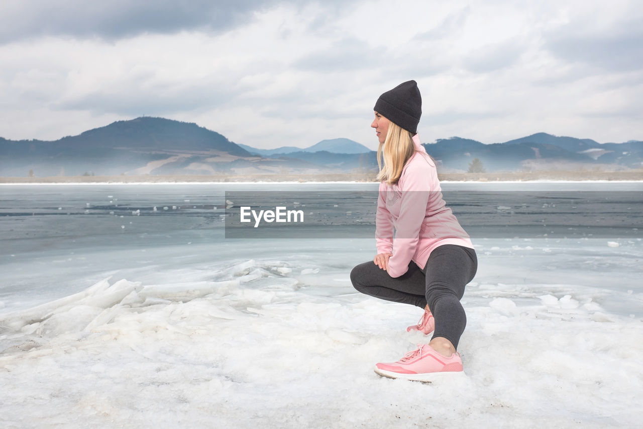 Running woman. runner is jogging in winter day. female fitness training outdoors around mountains.