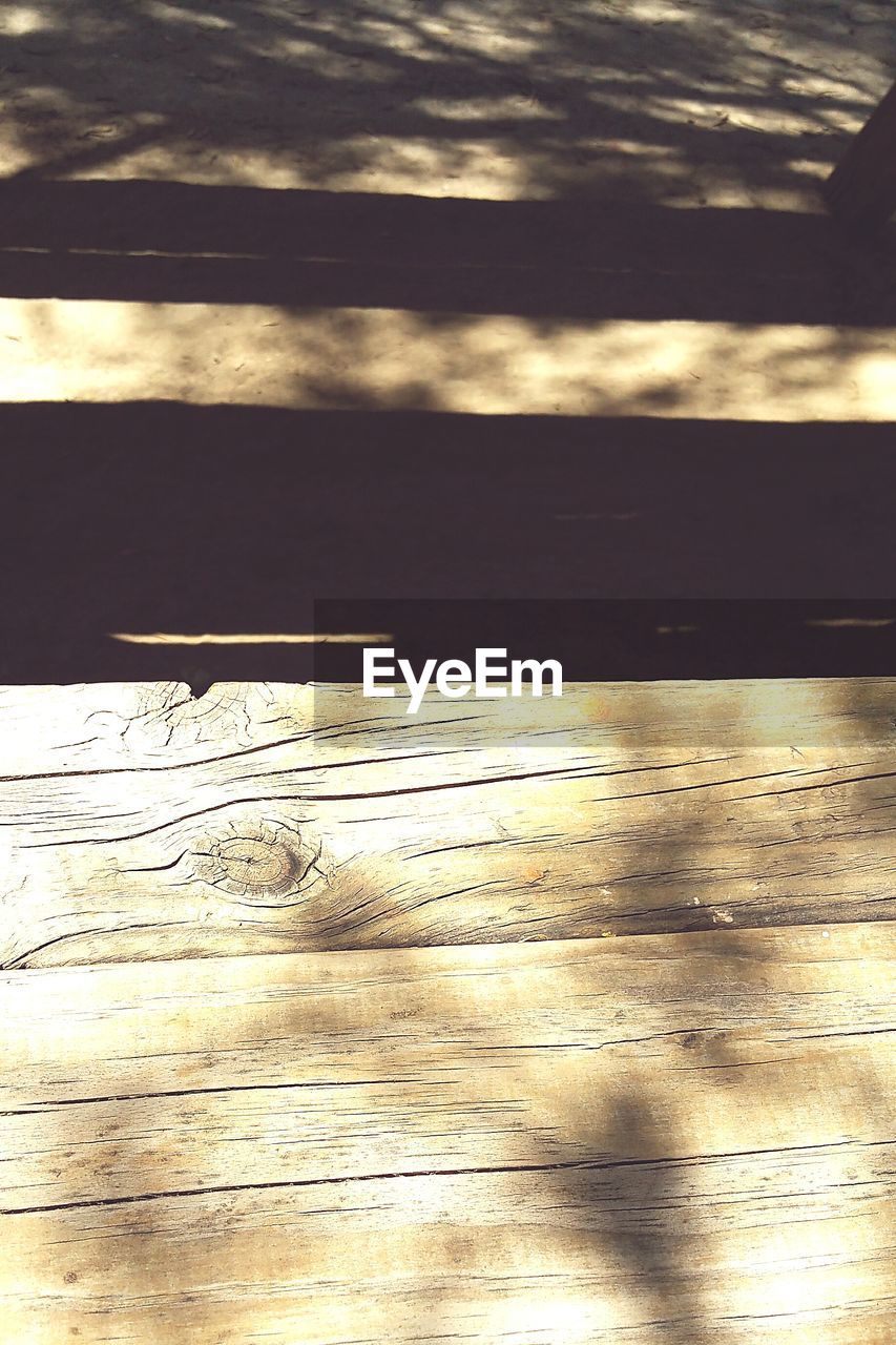 High angle view of sunlight falling on wooden table