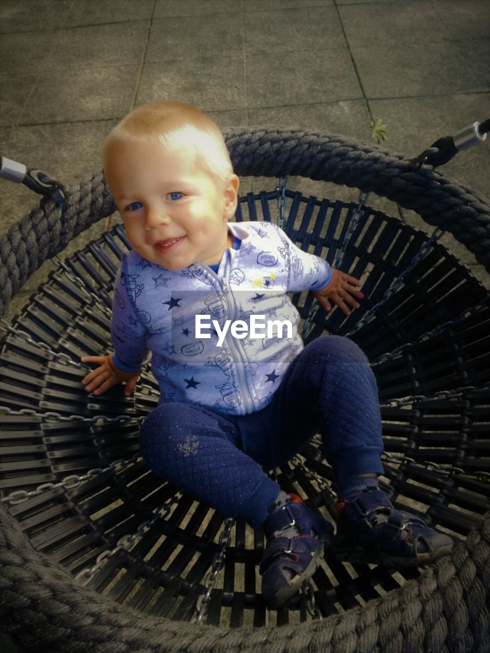 High angle portrait of boy sitting on play equipment