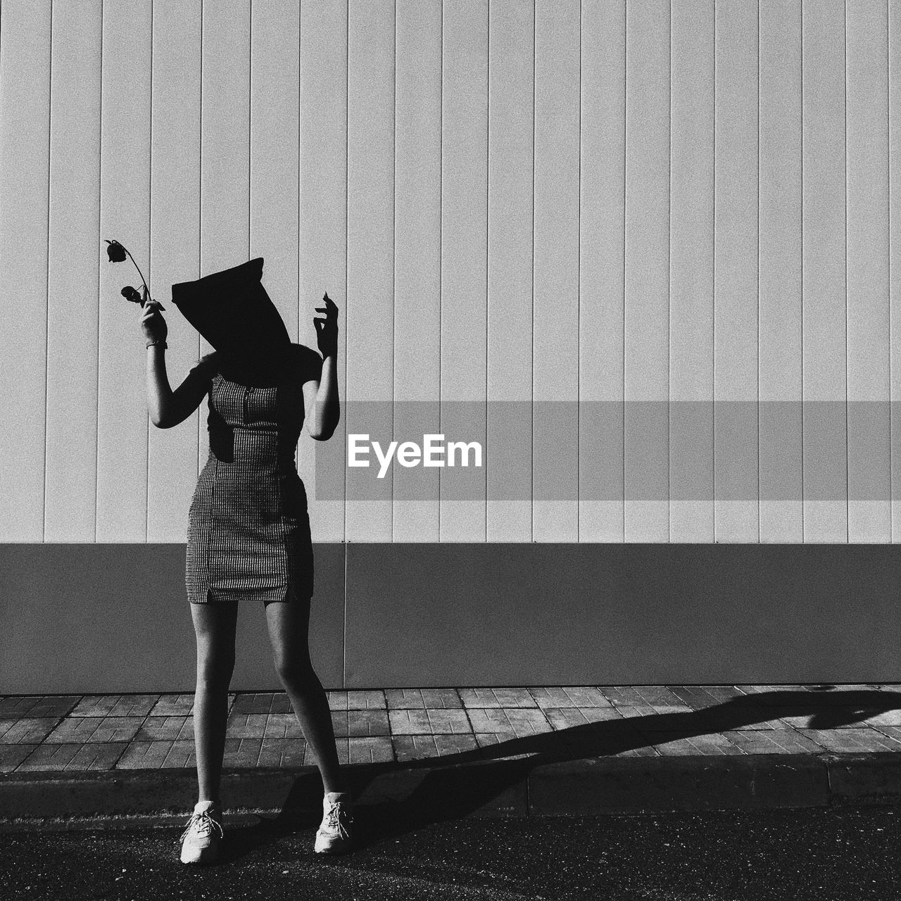 Rear view of woman standing against wall