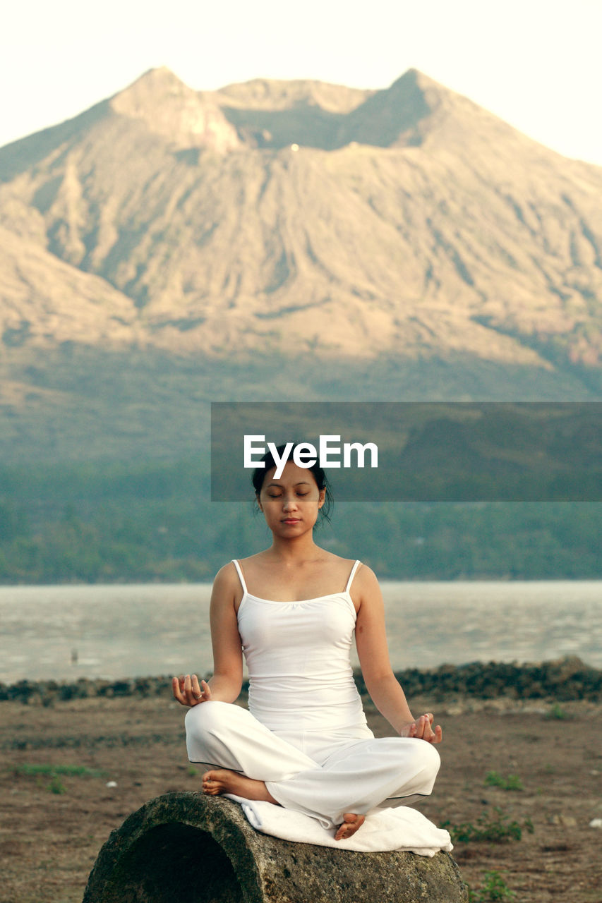 Woman doing yoga against mountains