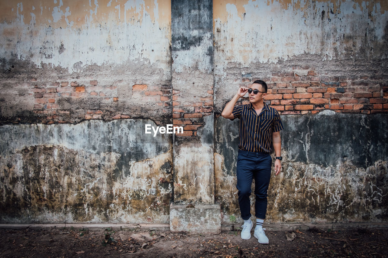 Man standing against wall in city