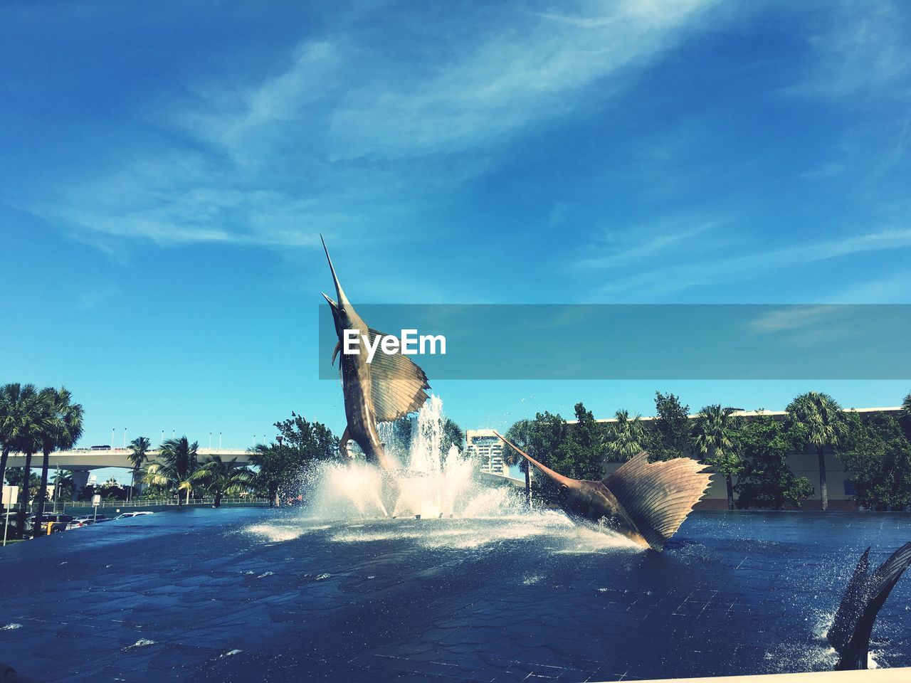 Swordfish statues in fountain against sky