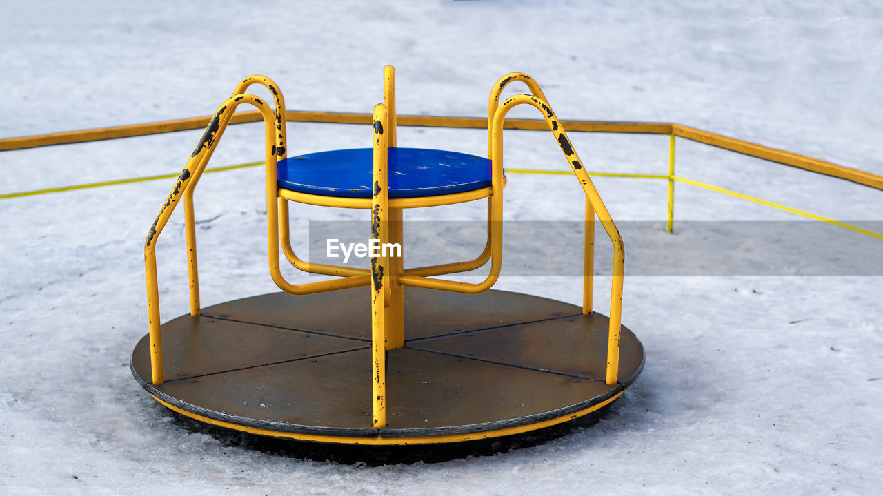 High angle view of yellow merry-go-round at playground during winter