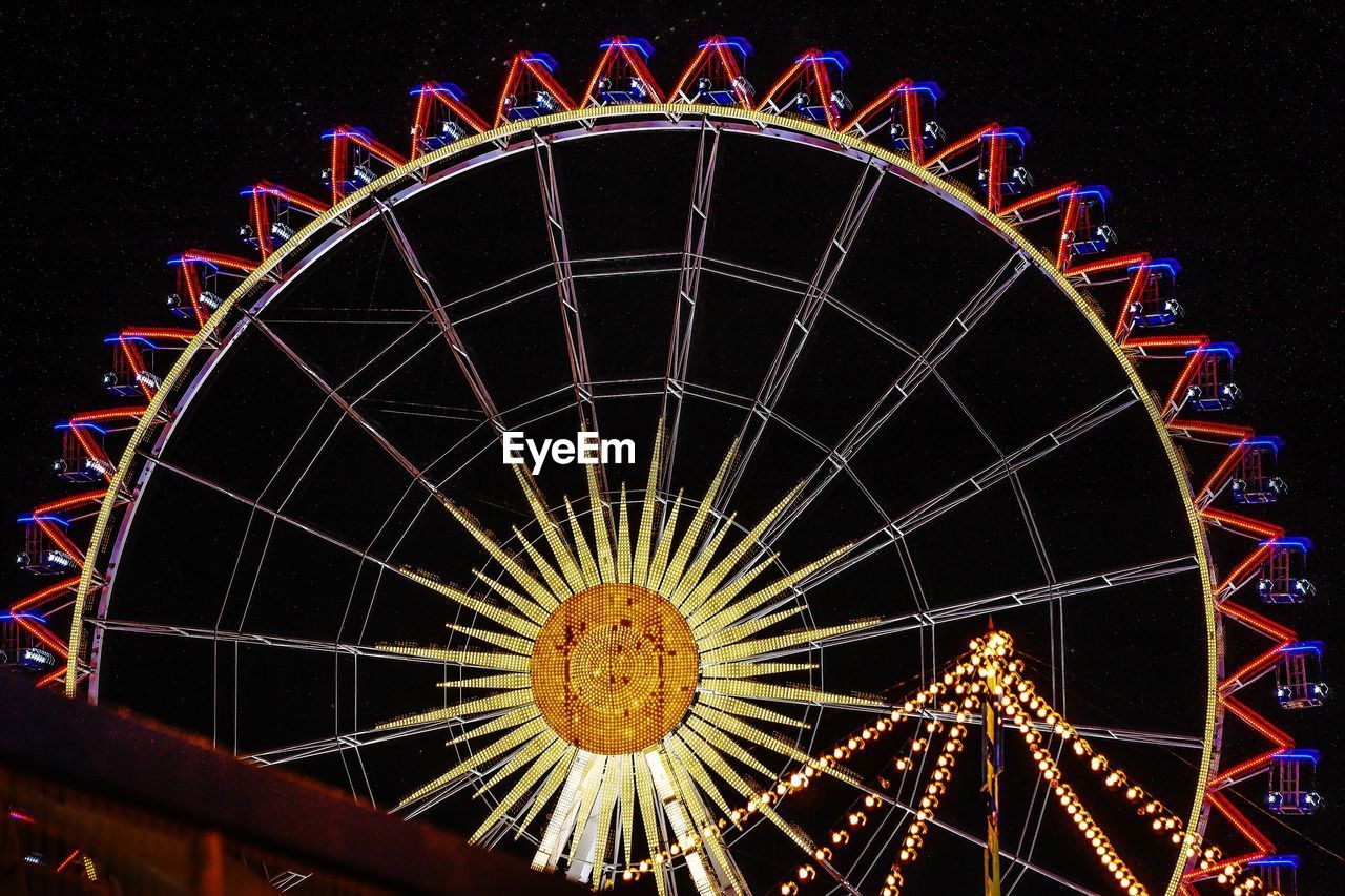 Low angle view of illuminated ferris wheel at night