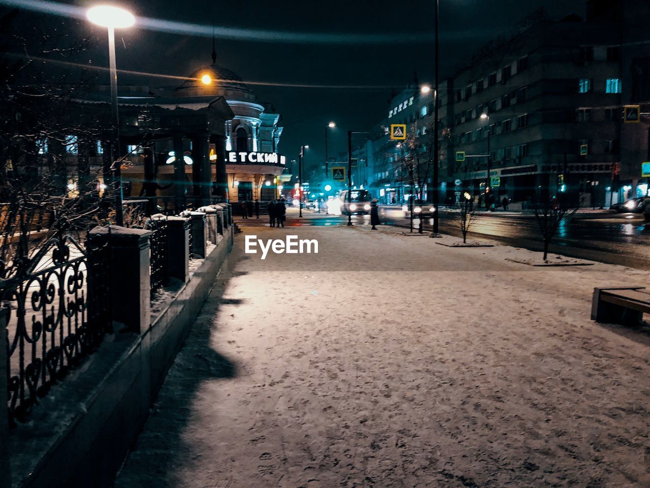 Illuminated street amidst buildings at night