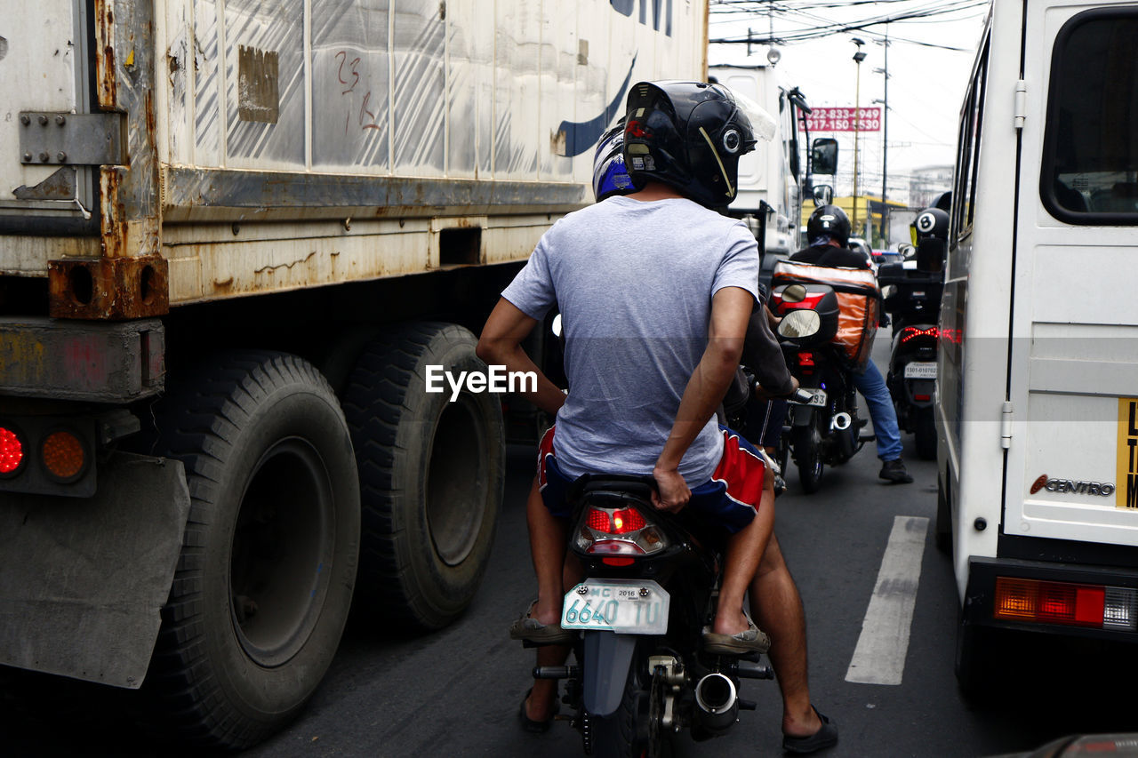 REAR VIEW OF MAN WORKING AT THE STREET