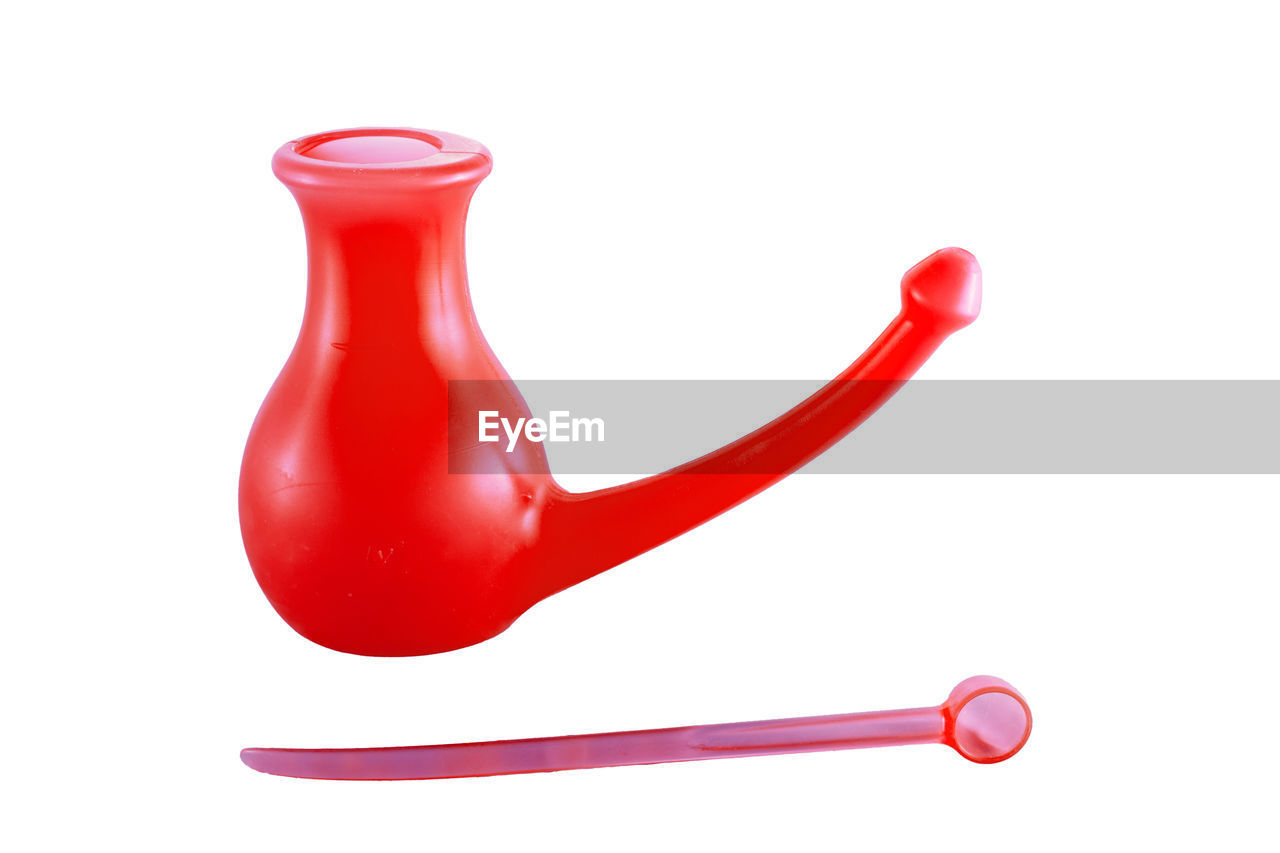 Red watering can against white background