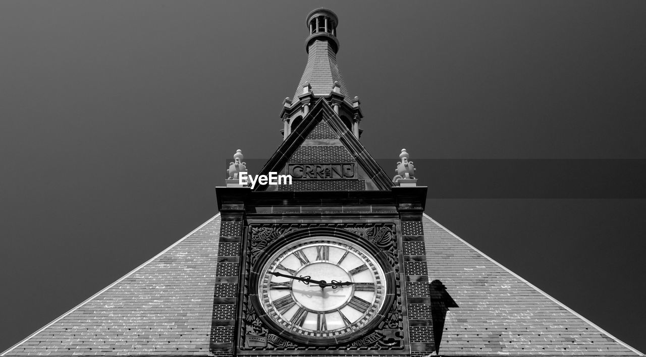 Low angle view of clock tower at railroad station against clear sky