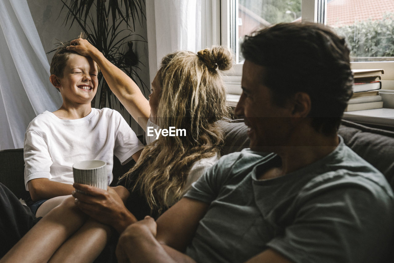 Happy parents spending time with son in living room