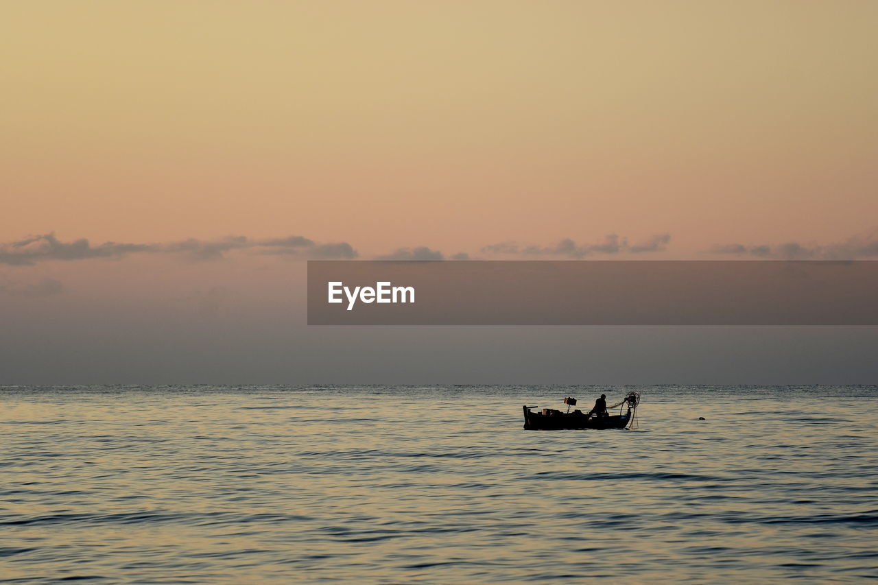 SILHOUETTE BOAT IN SEA AGAINST ORANGE SKY