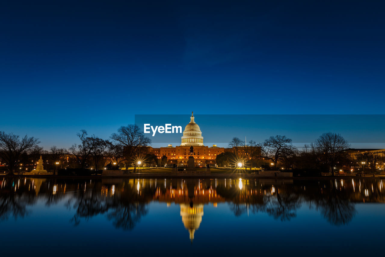 Illuminated united states capital dome with reflection on river at night