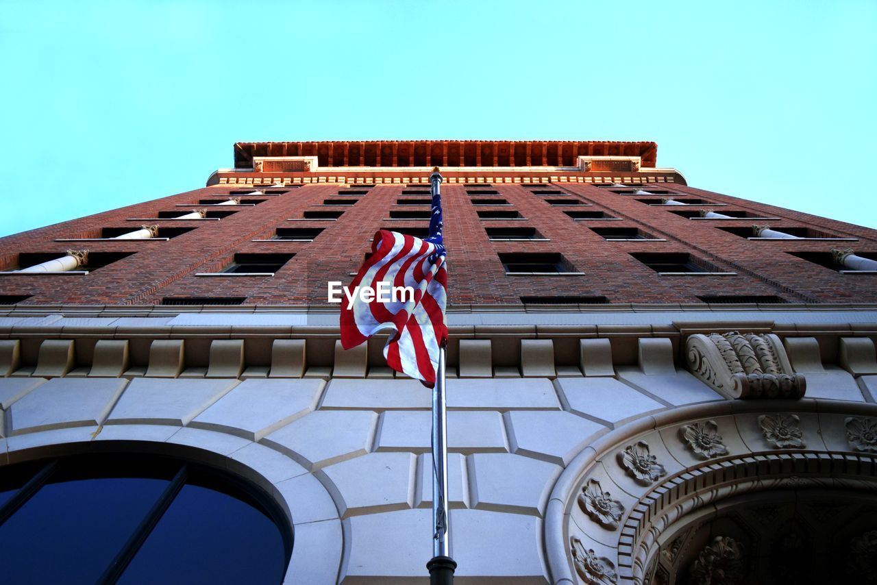 Low angle view of american flag against built structure