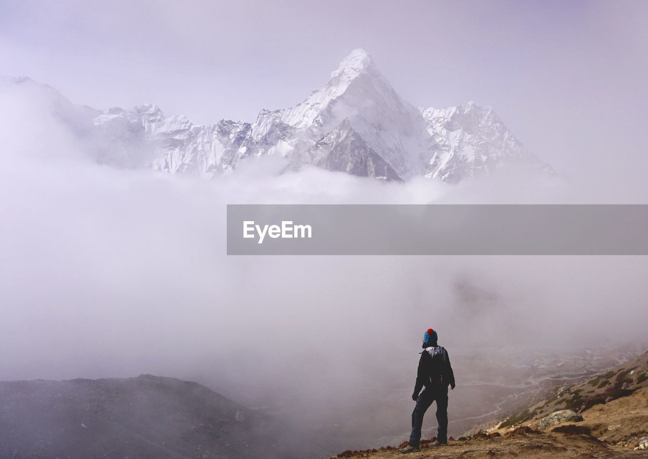 Rear view of woman on snowcapped mountain