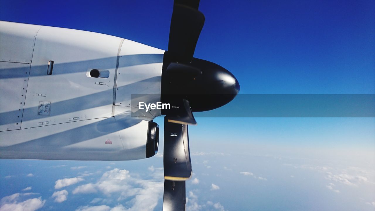 Close-up of airplane propeller against blue sky