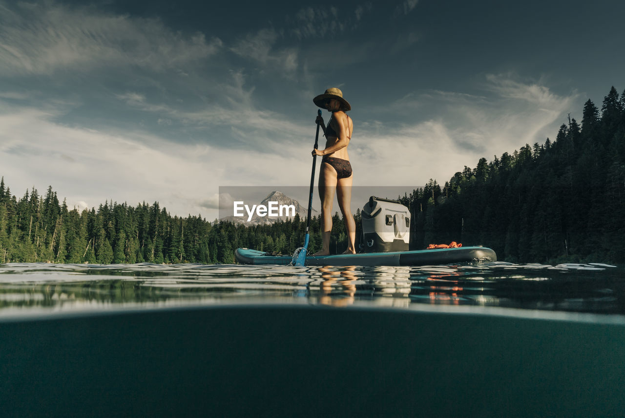 A young woman enjoys a standup paddle board on lost lake in oregon.