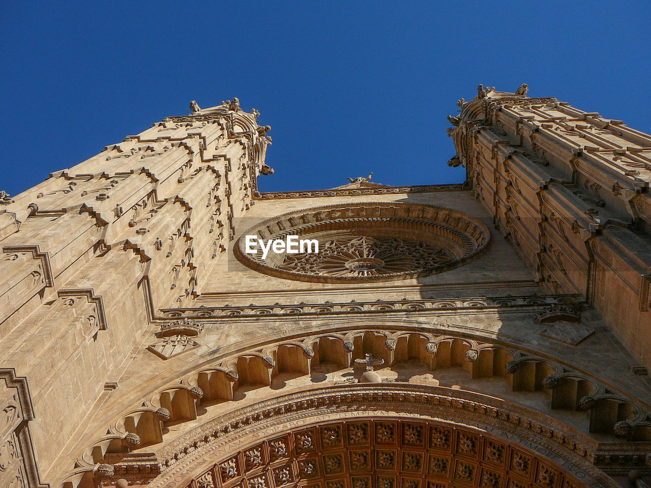 low angle view of old building against clear blue sky