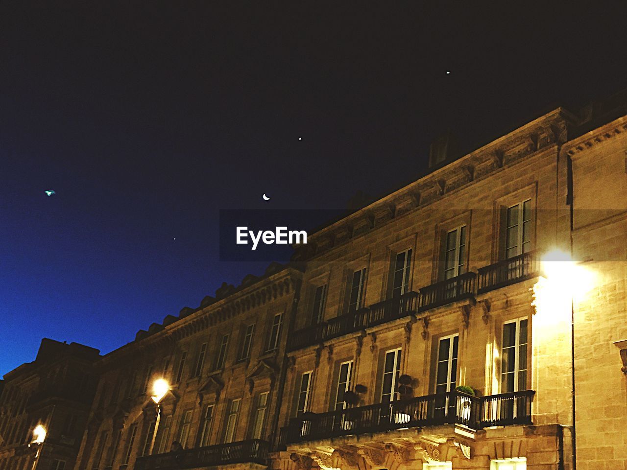 LOW ANGLE VIEW OF ILLUMINATED BUILDINGS AGAINST SKY