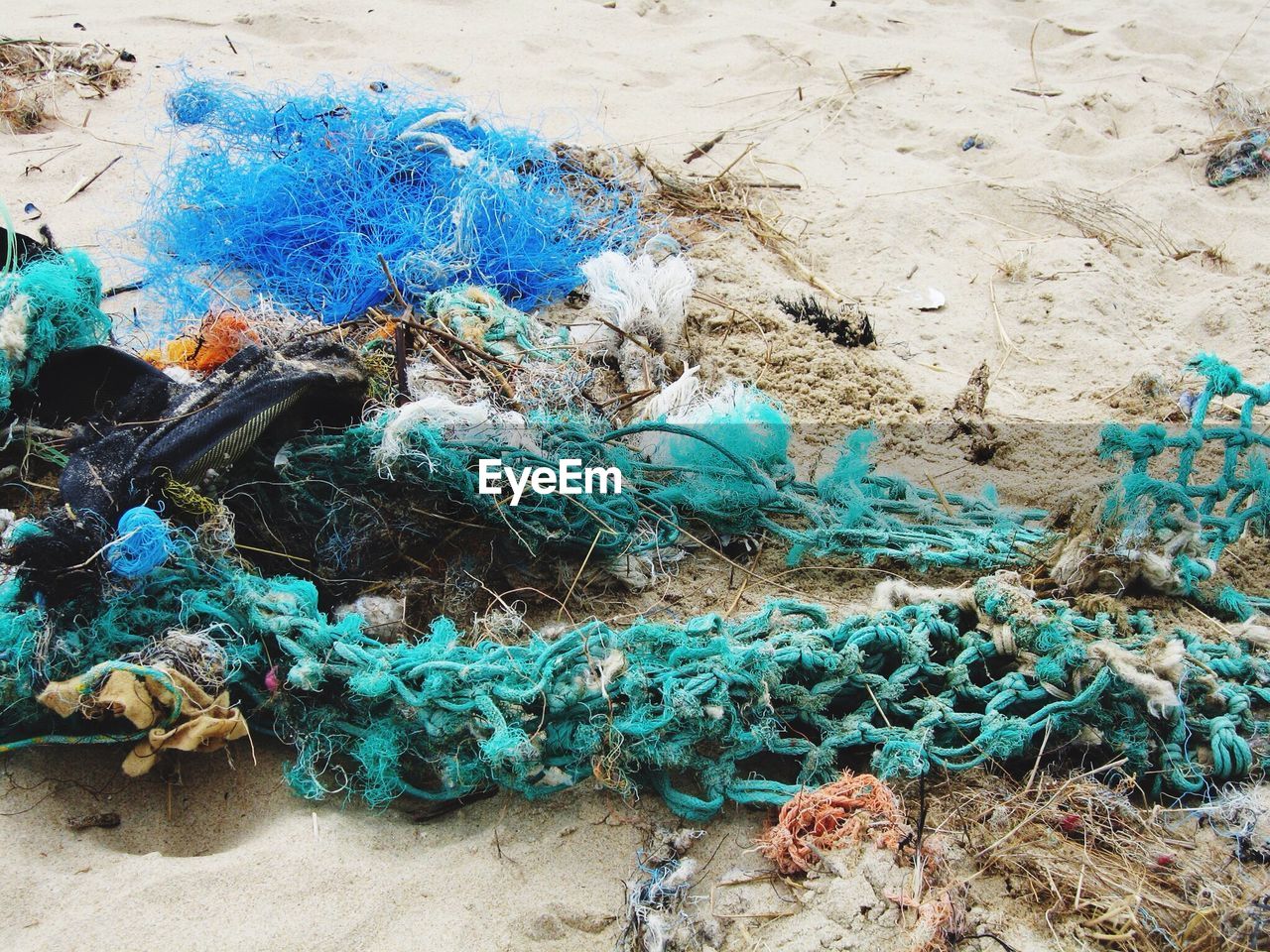 High angle view of messy fishing nets on sand