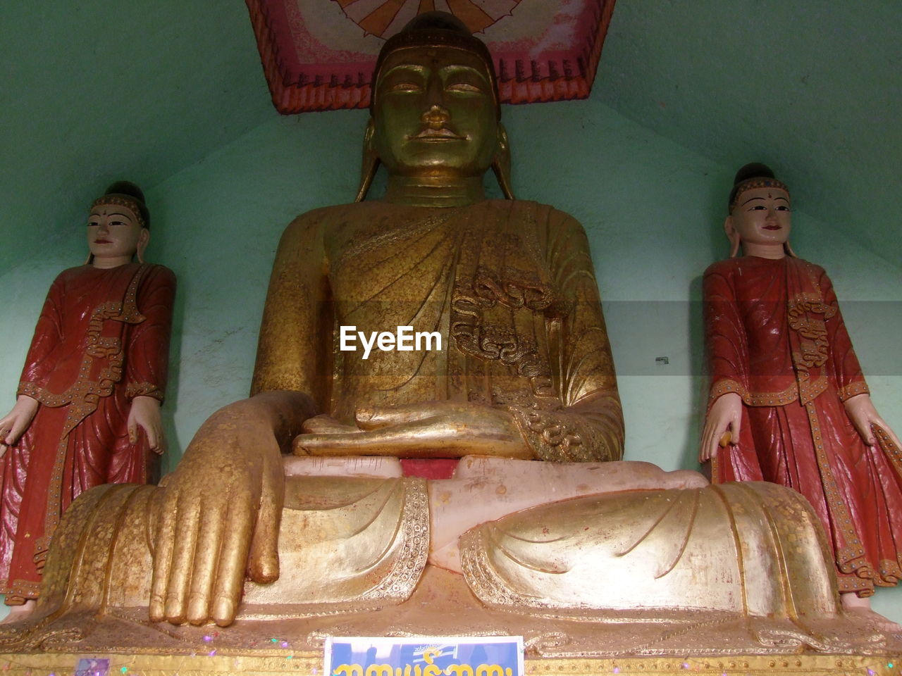 STATUE OF BUDDHA AGAINST TEMPLE