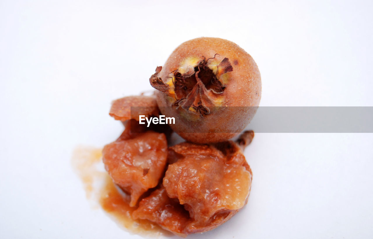 CLOSE-UP OF BREAD OVER WHITE BACKGROUND