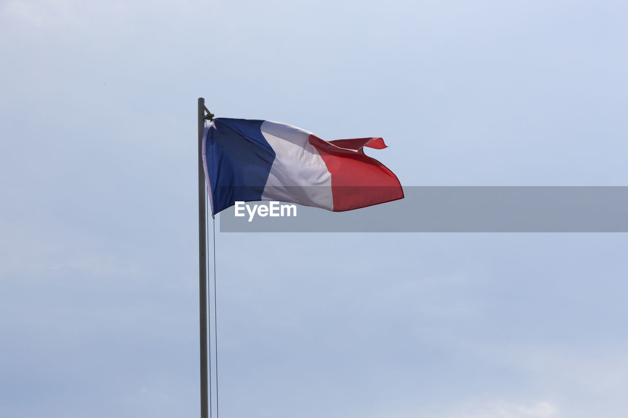 low angle view of flag against blue sky