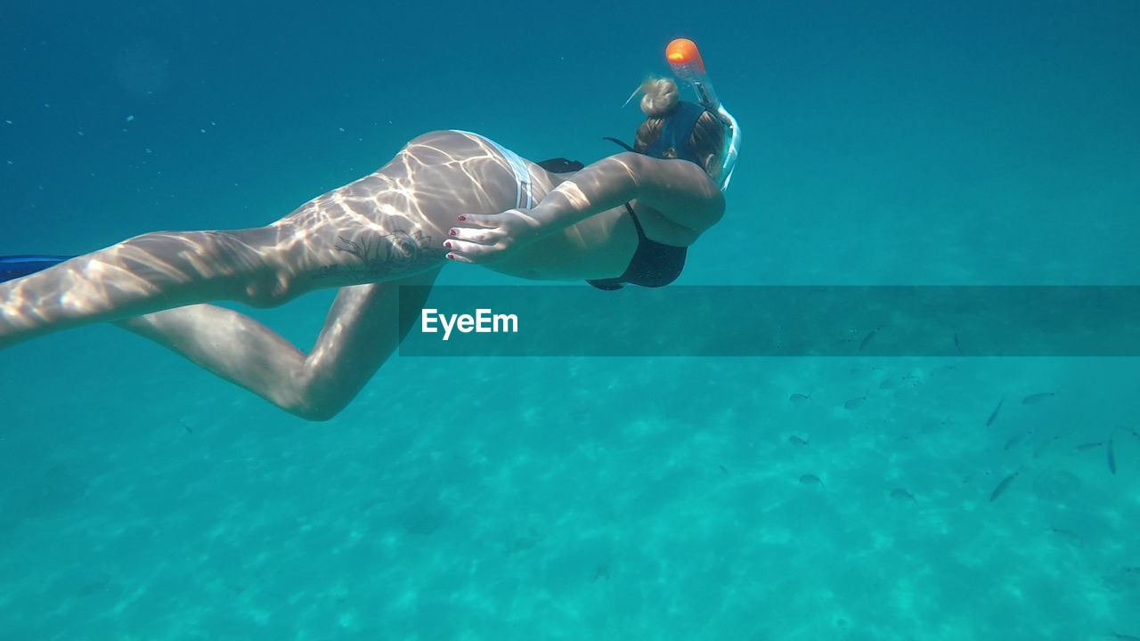 Full length of young woman swimming in sea