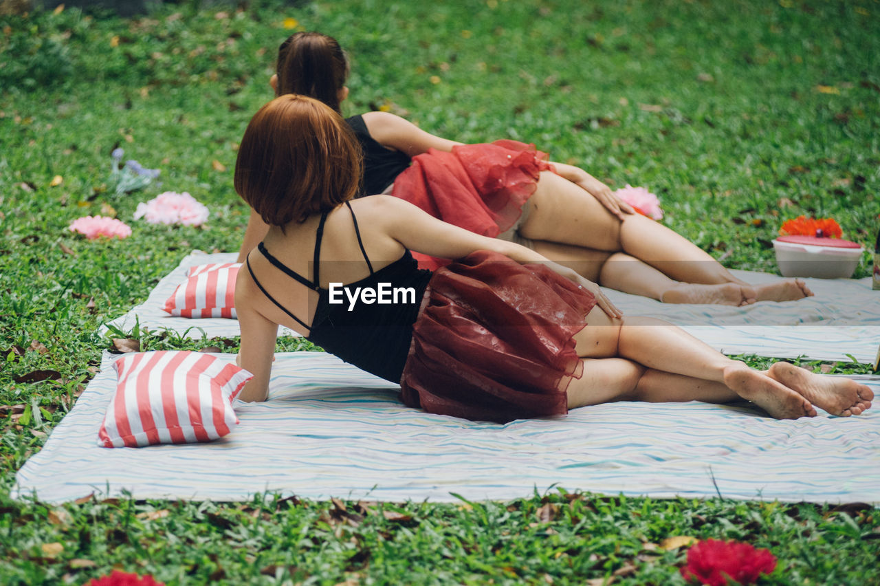 Rear view of women lying on grass