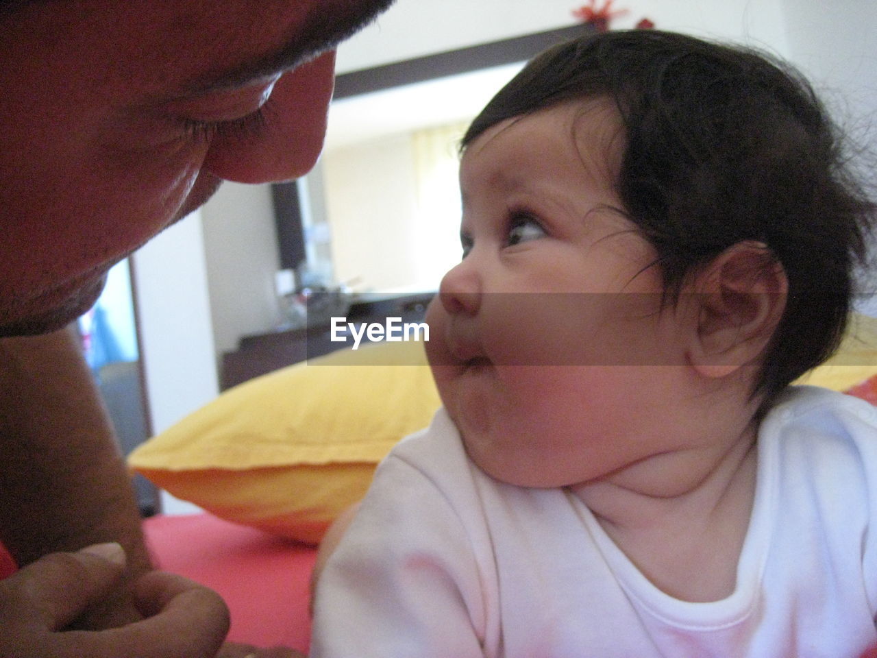 Close-up of baby girl with father at home