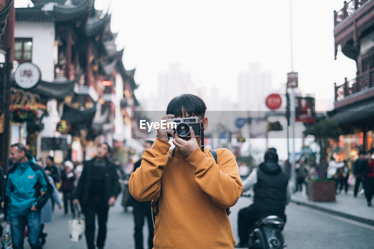 Man photographing on city street