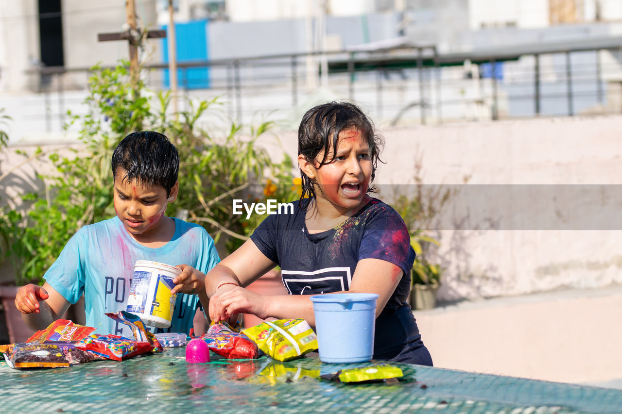 Two kids playing with colors on holi