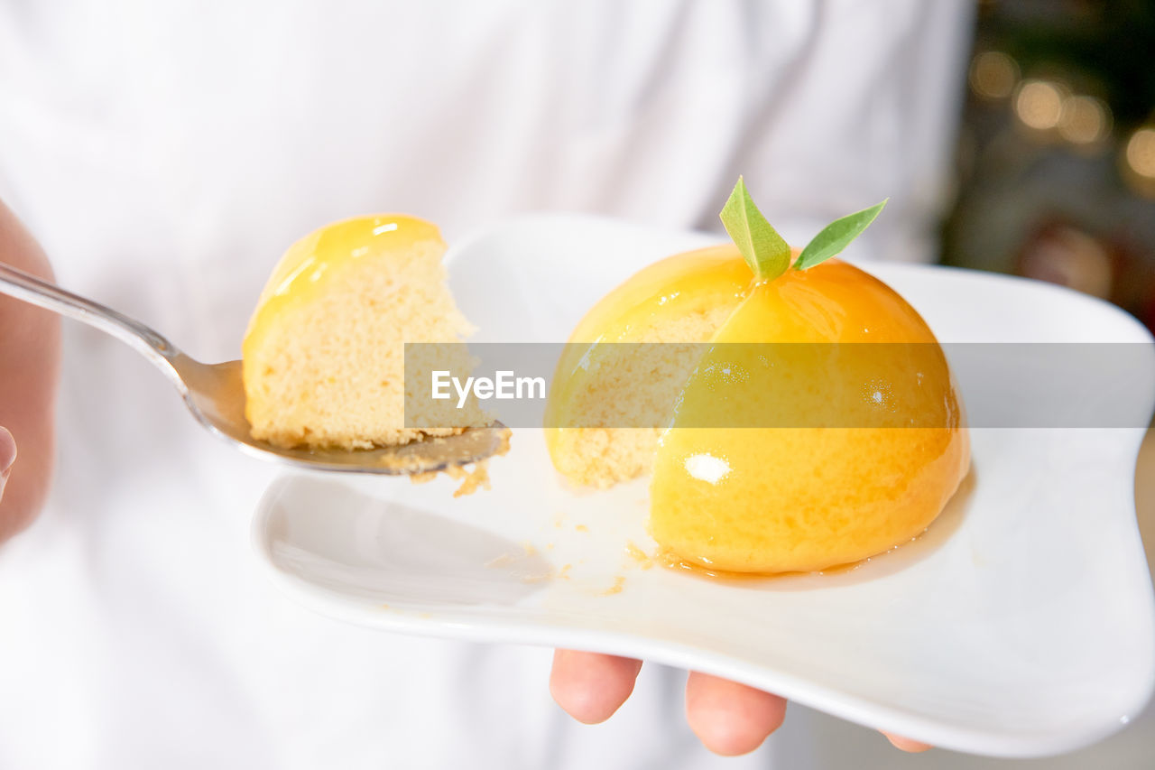 CLOSE-UP OF HAND HOLDING ICE CREAM WITH LEMON