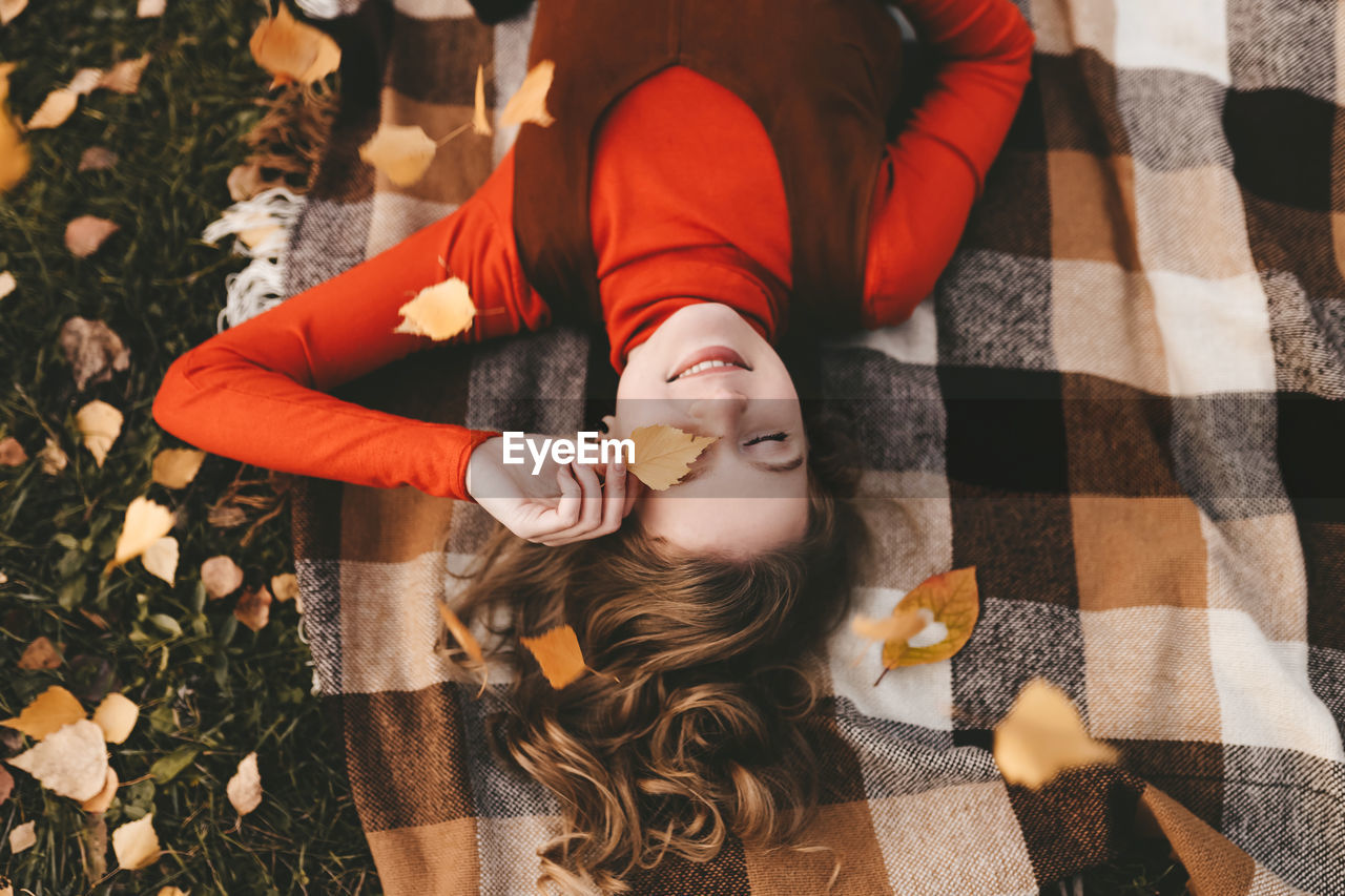 A pretty girl enjoys solitude drinks coffee walks in the autumn forest in nature in fall