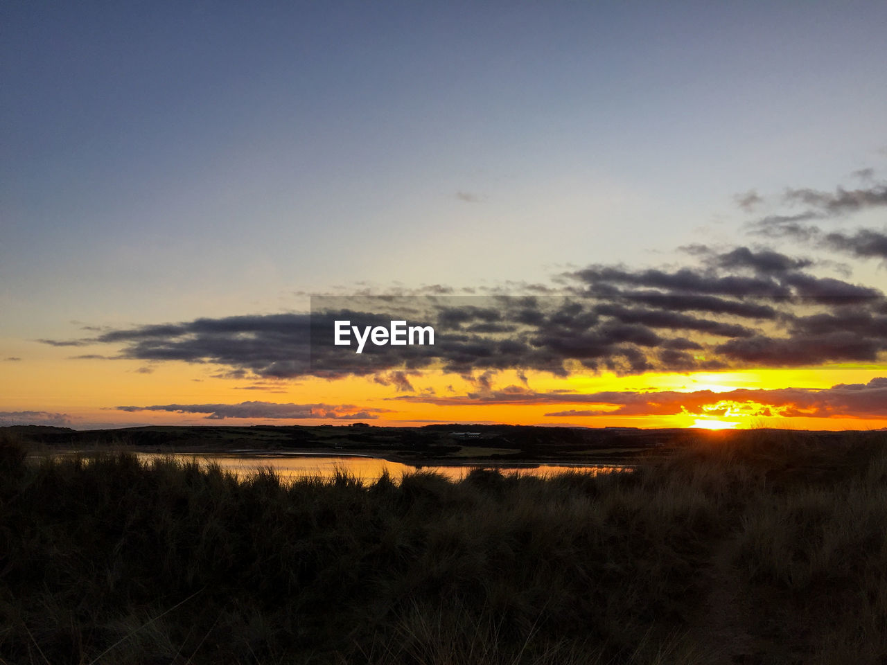 Scenic view of calm sea at sunset